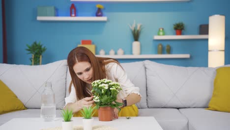 Young-woman-watering-flowers-at-home.-He-is-happy-and-enjoying.